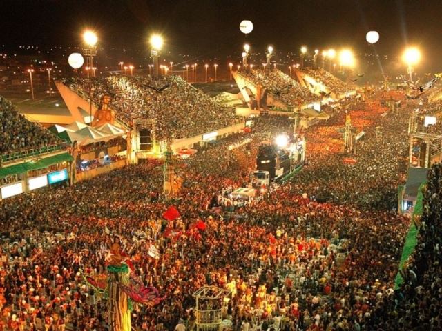 Vista aérea do Sambódromo de Manaus lotado durante o Boi Manaus, com arquibancadas iluminadas e público vibrando ao som das toadas.