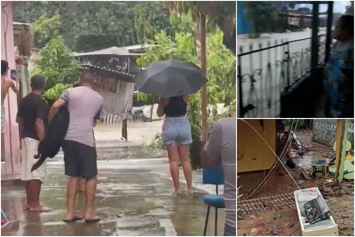 Moradores enfrentam chuva intensa e alagamento em área residencial, com casas atingidas pela água.