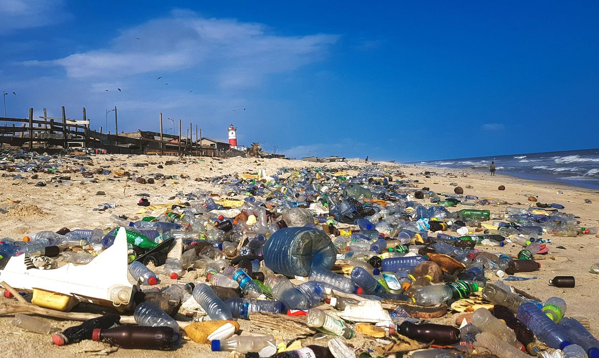 Praia cheia de resíduos de lixo plástico