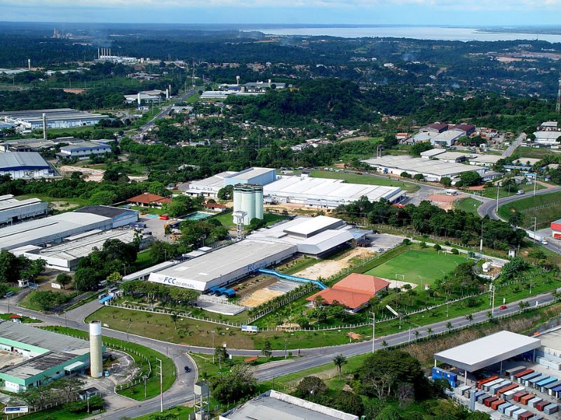Vista aérea do Polo Industrial de Manaus com fábricas, vias internas e área verde.