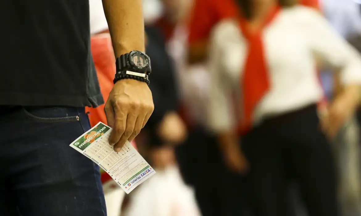 Apostador carrega bilhete da Mega-Sena