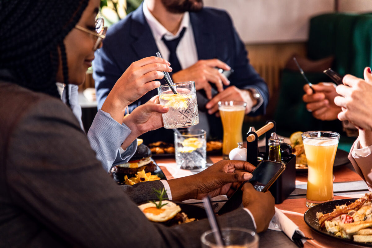 Pessoas bebem à mesa em bar, ilustrando consumo de bebidas alcoólicas no Brasil