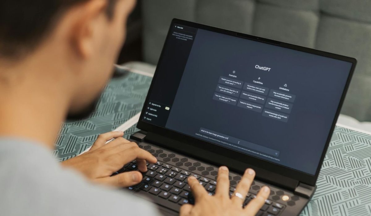 Homem digitando em um laptop com a interface do ChatGPT visível na tela, representando o uso da inteligência artificial no Brasil