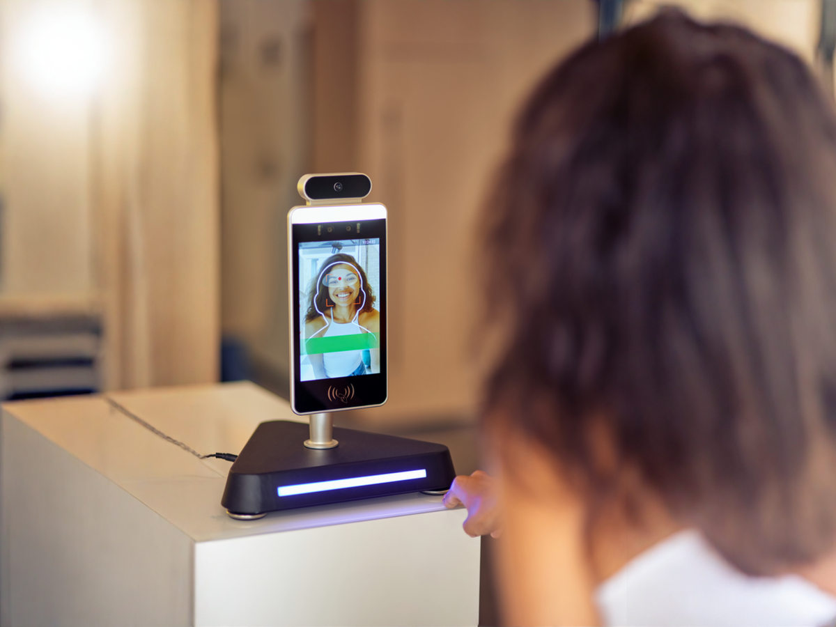 Uma pessoa olhando para a tela de um celular sendo reconhecida pelo sistema de biometria facial, representando a tecnologia de segurança digital.