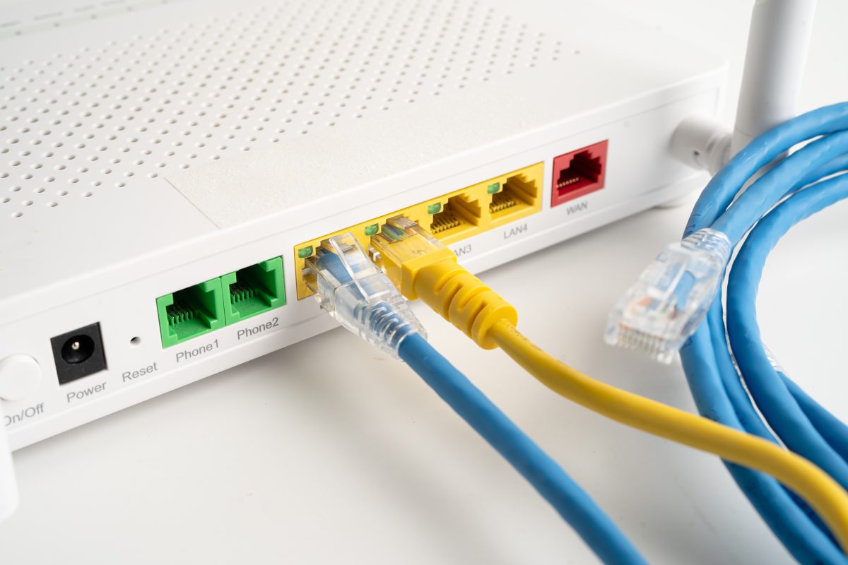 Roteador e cabos de rede, representando a transição da internet discada para as tecnologias modernas de banda larga e fibra óptica