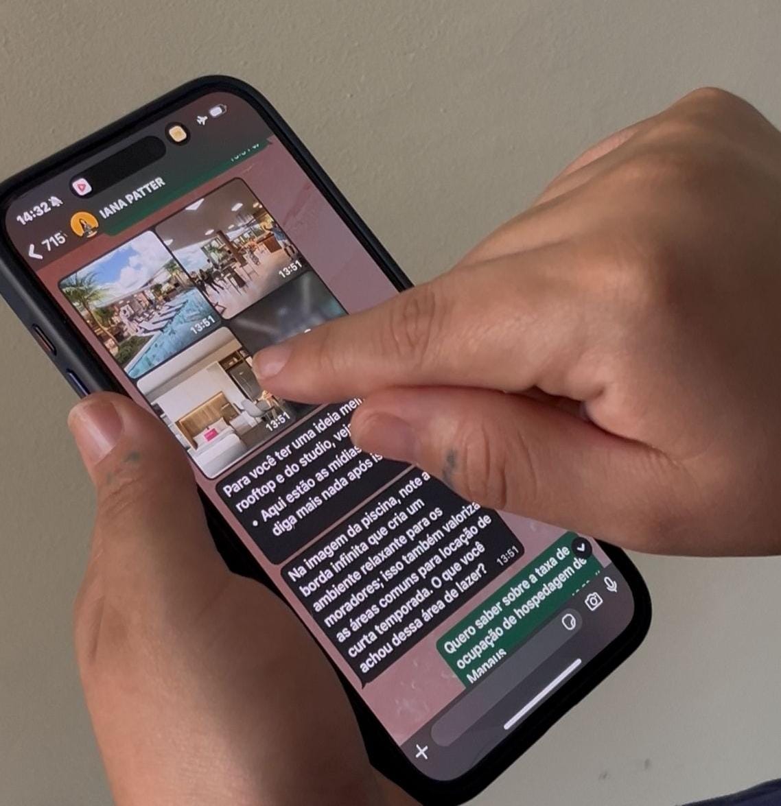 Mãos de uma pessoa utilizando a IAna, assistente virtual do setor imobiliário, em um celular