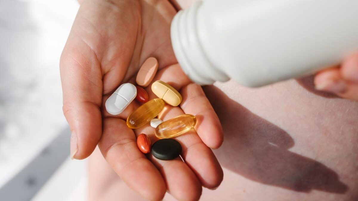 pessoa derramando suplementos na mão ilustra proibição da Anvisa