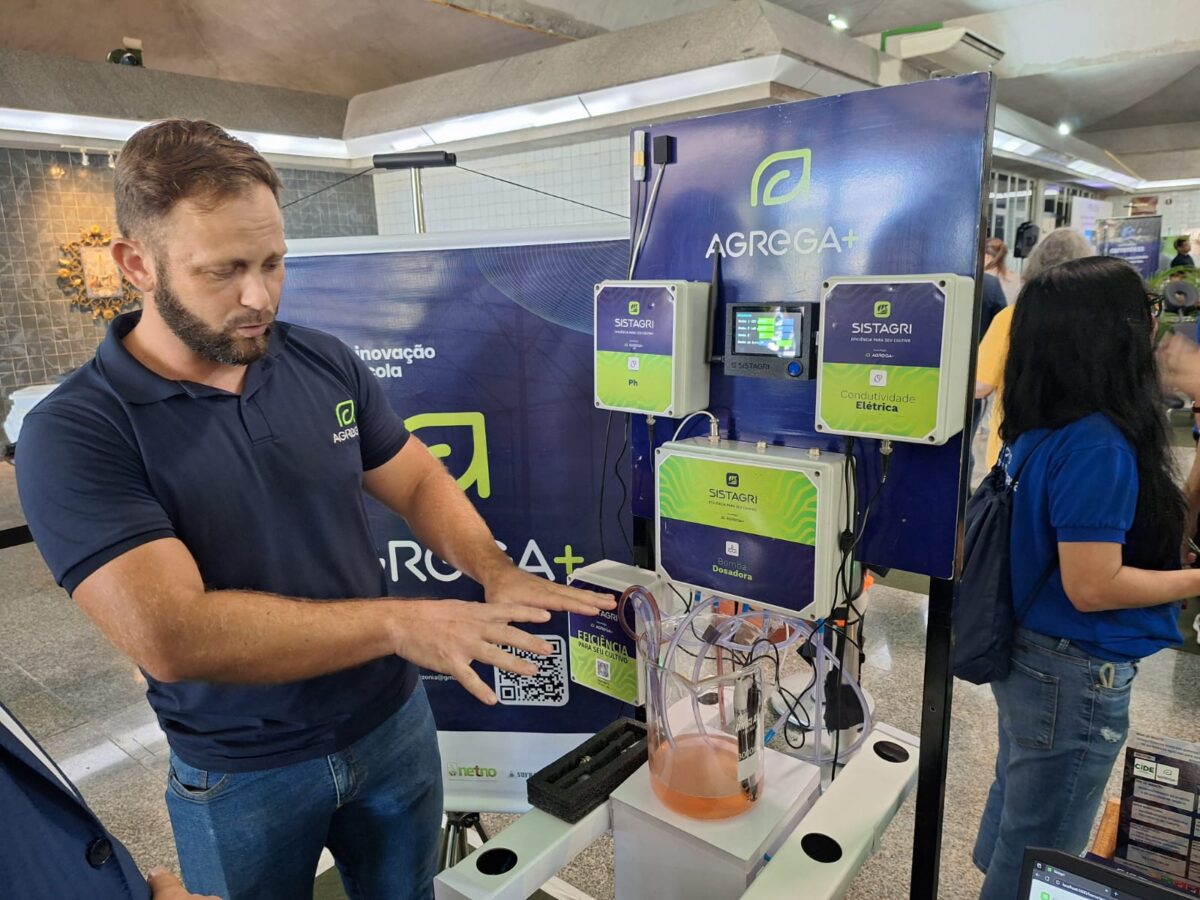 André Golveia Belota, gerente agrícola da Agrega+, demonstra o sistema Sistagri com sensores e painéis eletrônicos que controlam variáveis da hidroponia durante evento de inovação em Manaus.