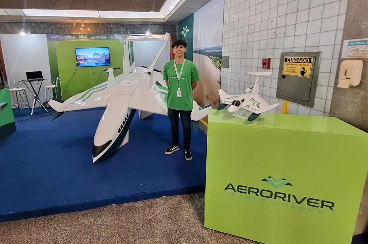 Desenvolvedor da AeroRiver posa ao lado do protótipo do Volitan, barco voador amazônico exposto em evento de inovação