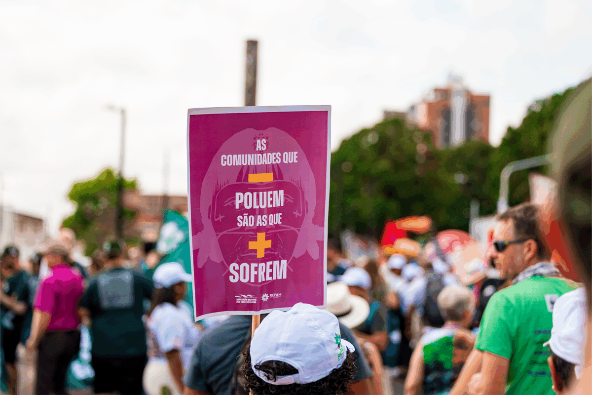 ALT TEXT (Texto alternativo) Cartaz em manifestação na COP30 com frase sobre desigualdade ambiental.