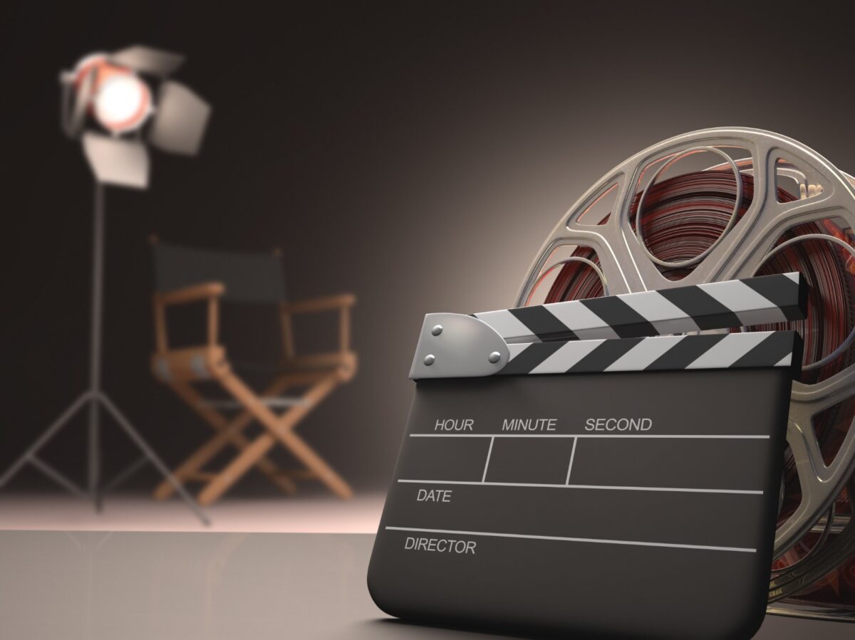 Claquete e rolo de filme em estúdio simbolizam o setor audiovisual brasileiro.