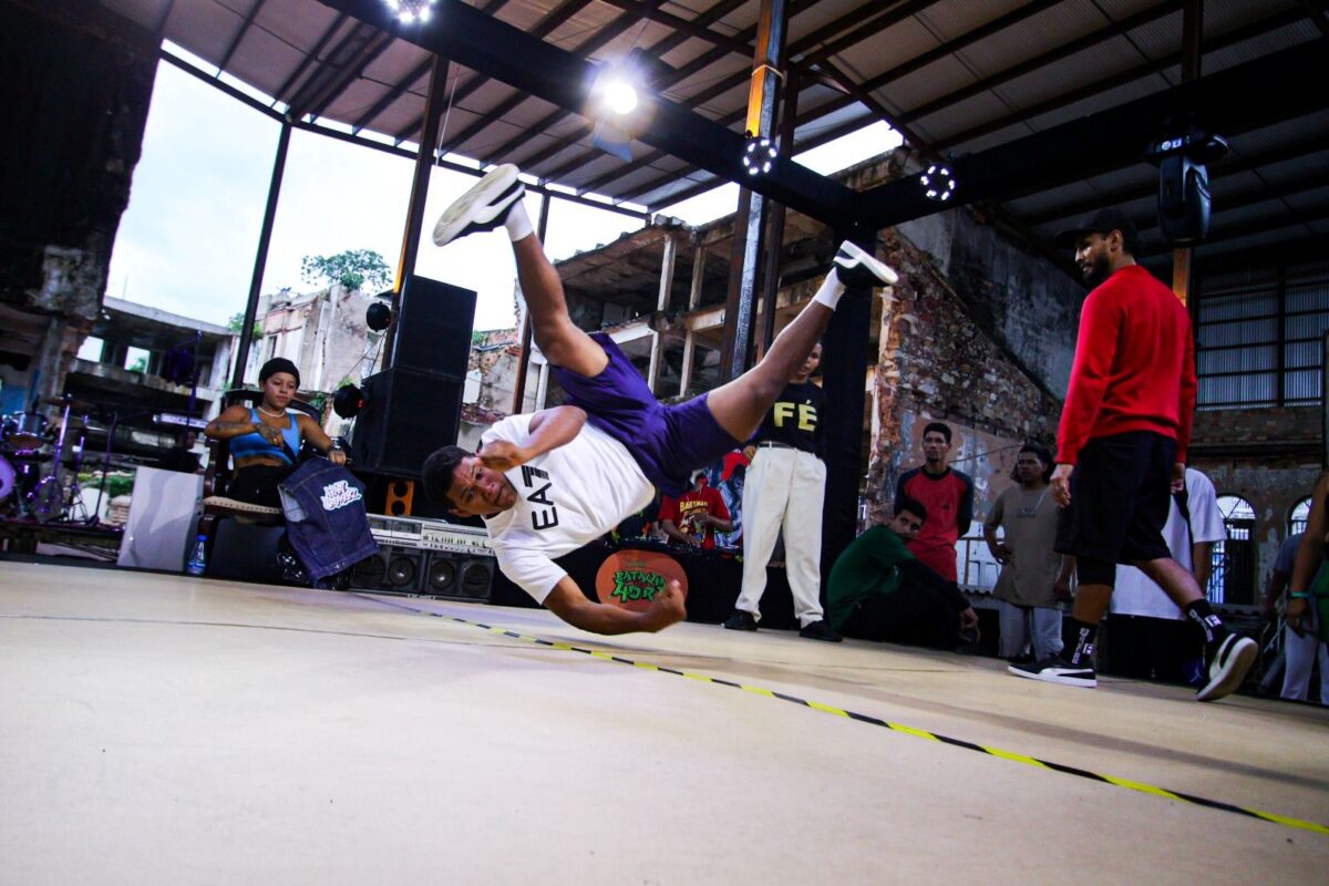 Dançarino de breaking executa movimento acrobático durante batalha de hip hop em Manaus.