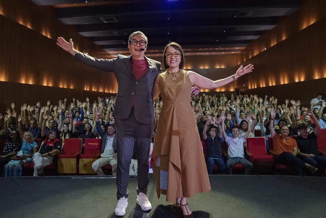 Carlos e Gisele Oshiro, sorridentes e de braços abertos no palco do Teatro ICBEU, diante de uma plateia lotada, celebram o sucesso da palestra “O poder dos chatos” e “Nada fora do lugar”, realizada em Manaus.