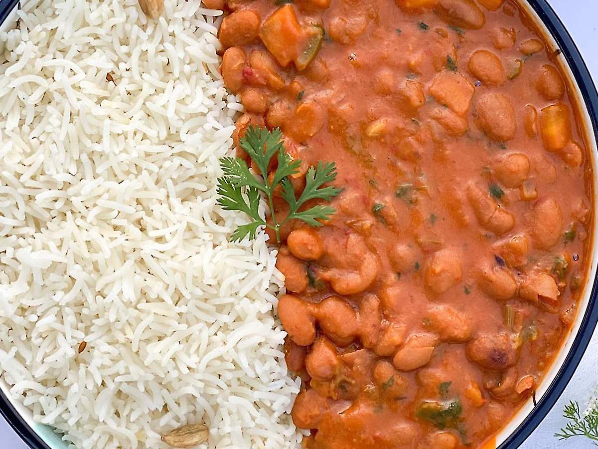 Prato com arroz branco e feijão cozido servido lado a lado visto de cima