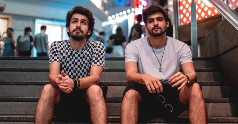 Dupla de DJs Cat Dealers sentada em escadaria durante divulgação da 444 White Party em Manaus