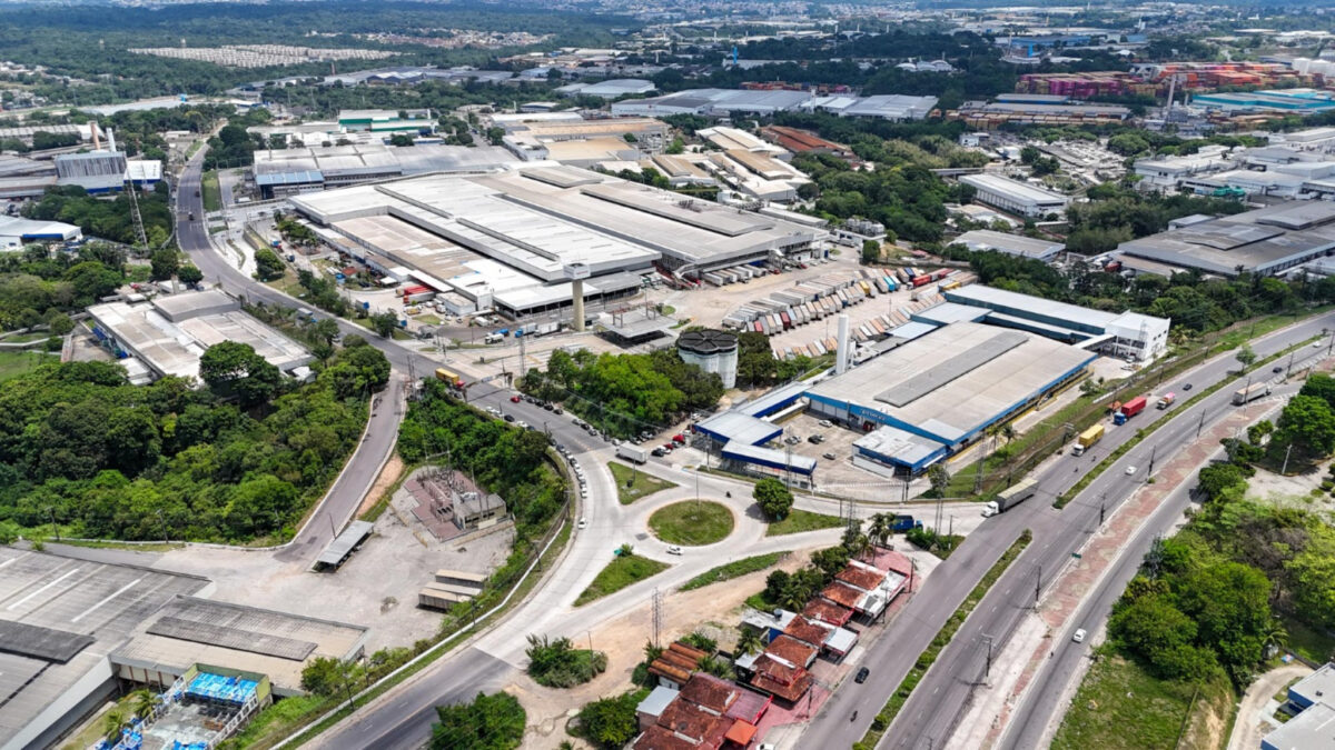 Vista aérea do Polo Industrial de Manaus com galpões industriais e vias de acesso.