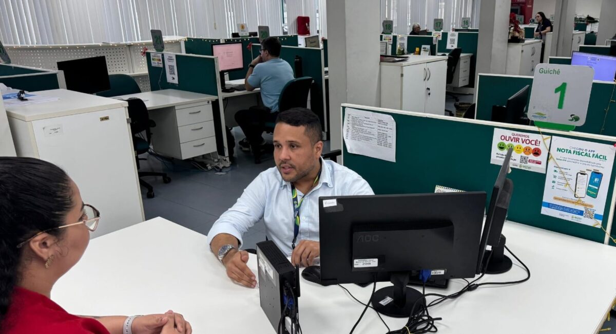 Servidor da Sefaz-AM atende contribuinte em guichê durante orientações sobre o Refis 2025, em Manaus.