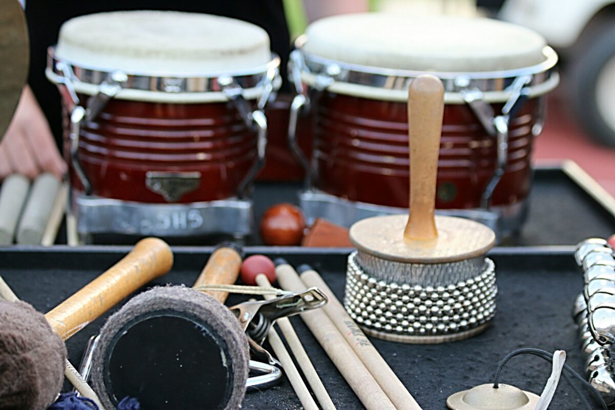 Instrumentos de percussão como bongôs, baquetas e chocalhos organizados para apresentações de samba.