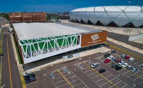 Vista aérea do Centro de Convenções Vasco Vasques ao lado da Arena da Amazônia, com estacionamento e estruturas externas.