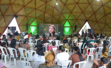 Lideranças indígenas assistem a uma plenária na Aldeia COP, estrutura montada na Universidade Federal do Pará durante a COP30, com debates sobre justiça climática, segurança alimentar e demarcação de terras.