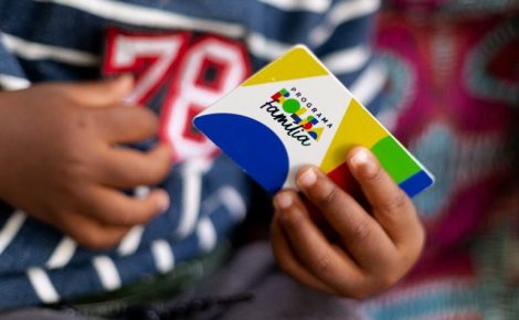Cartão do Bolsa Família nas mãos de uma criança (Foto: Lyon Santos / MDS)