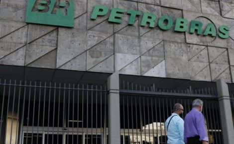 Fachada da Petrobras com logotipo da estatal e pessoas caminhando em frente ao prédio