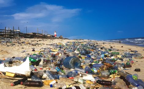 Praia cheia de resíduos de lixo plástico
