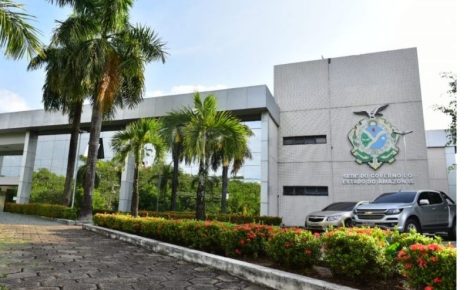 Fachada da sede do Governo do Amazonas em Manaus, com bandeira e área externa arborizada.