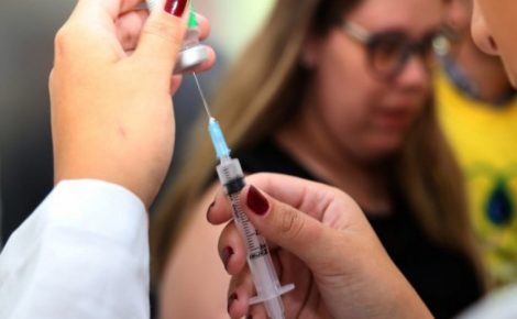 Profissional de saúde realiza vacinação contra a dengue durante campanha de busca ativa.