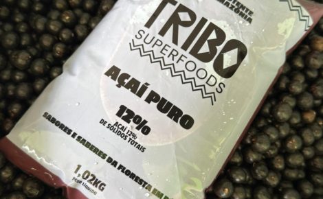 Embalagem de açaí puro da Tribo Superfoods sobre frutos de açaí recém-colhidos no Pará