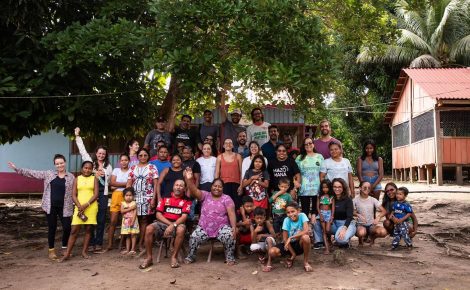 Grupo de moradores e representantes da Amaz Aceleradora reunidos em comunidade ribeirinha na Amazônia.