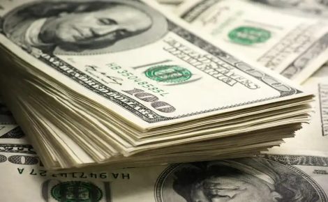 Cédulas de dólar americano empilhadas, simbolizando o comportamento do câmbio e a valorização da moeda dos EUA frente ao real.
