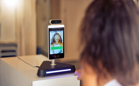 Uma pessoa olhando para a tela de um celular sendo reconhecida pelo sistema de biometria facial, representando a tecnologia de segurança digital.