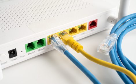 Roteador e cabos de rede, representando a transição da internet discada para as tecnologias modernas de banda larga e fibra óptica
