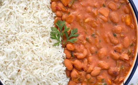 Prato com arroz branco e feijão cozido servido lado a lado visto de cima