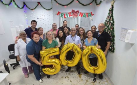 Equipe da Fundação Hospitalar Alfredo da Matta reunida em centro cirúrgico durante mutirão do Opera+ Amazonas, segurando balões com o número 500.