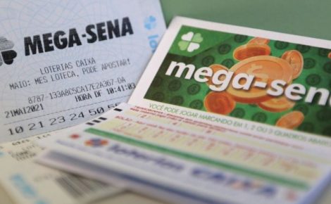Volantes e bilhetes da Mega-Sena sobre mesa, representando o prêmio acumulado