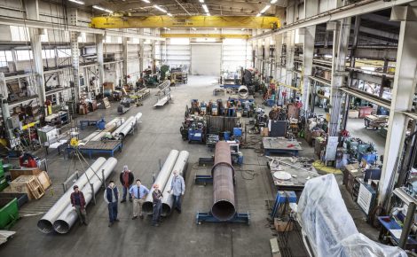 mixed race team of workers and management people in a large sheet metal factory