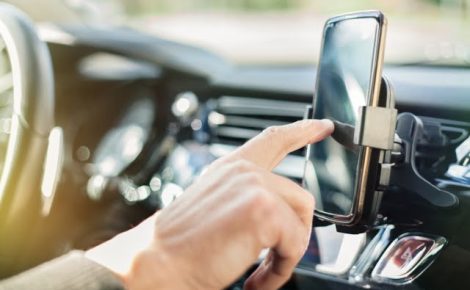 Close up of a man using smart phone while driving