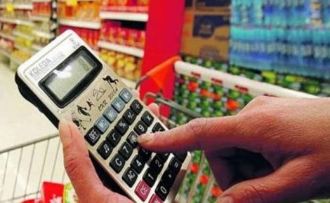 Cliente calcula preços em supermercado no Brasil, refletindo a diferença entre IPCA e inflação do dia a dia.