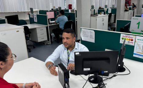 Servidor da Sefaz-AM atende contribuinte em guichê durante orientações sobre o Refis 2025, em Manaus.