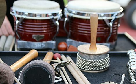 Instrumentos de percussão como bongôs, baquetas e chocalhos organizados para apresentações de samba.