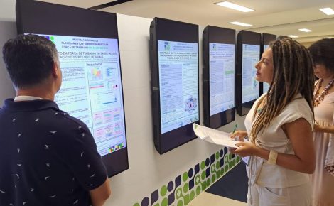 Servidores observam painéis digitais com projetos apresentados na Mostra Nacional de Planejamento em Saúde, em Brasília.