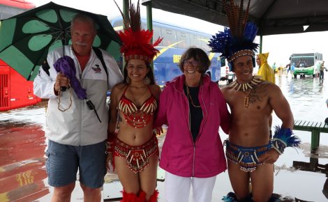 Turistas posam com dançarinos dos bois Garantido e Caprichoso em Parintins durante evento cultural