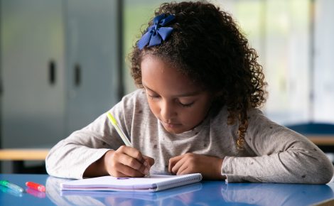 Criança escreve em caderno Foto: Freepik