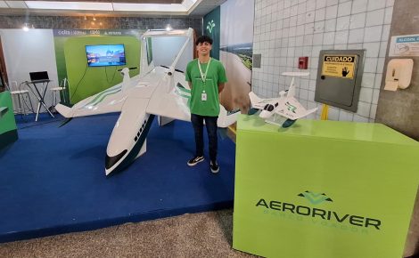 Desenvolvedor da AeroRiver posa ao lado do protótipo do Volitan, barco voador amazônico exposto em evento de inovação